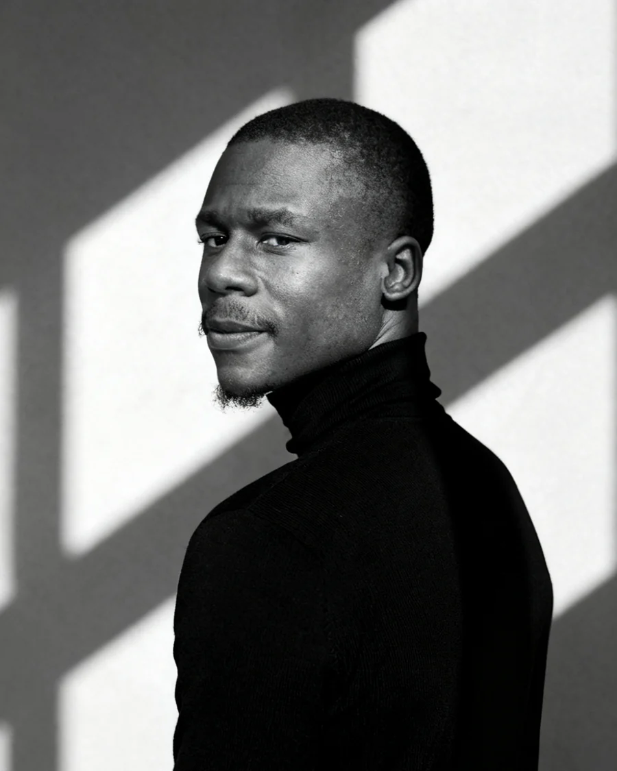 Oluwatobi Ajidahun, founder of FJMK, in a black turtleneck under directional light